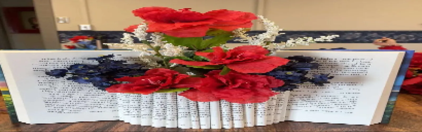 Handmade book vase with red, white, and blue flowers